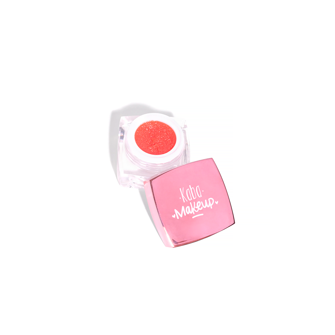 Envase abierto del Exfoliante de Labios Kaba Makeup (15g) mostrando la textura granular rosa del producto, junto a su tapa cuadrada rosa con el logo de la marca.